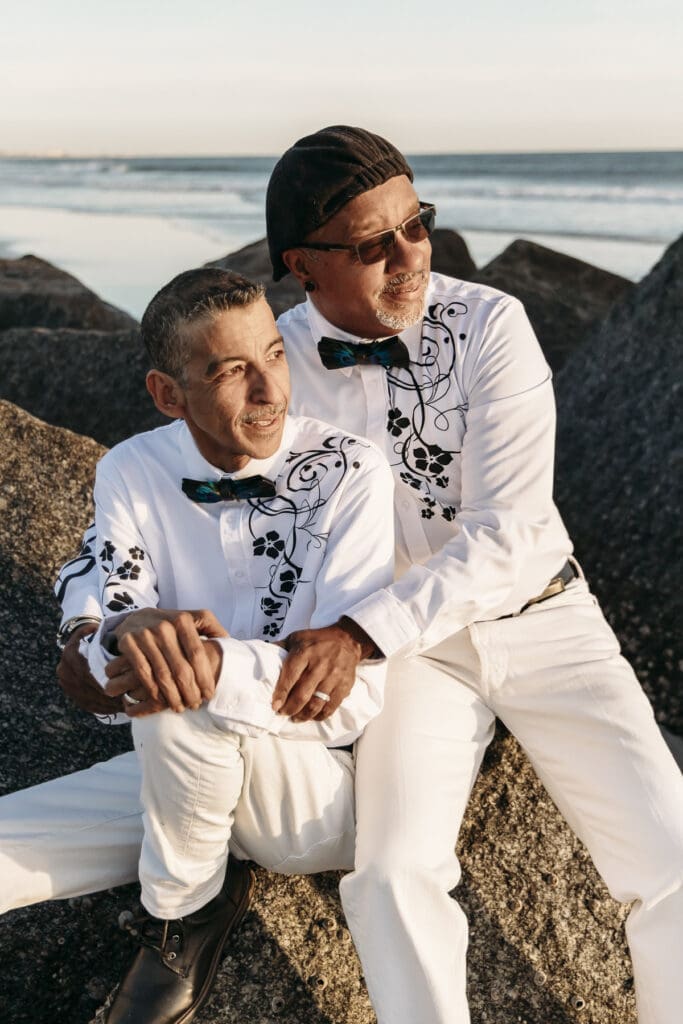 Married couple sitting on rocks smiling
