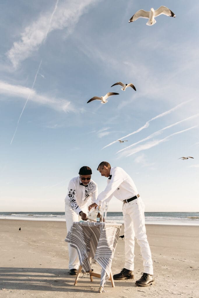 Gay couple who just eloped cutting cake on the beach